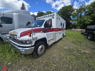 Ambulance vehicle 2007 Chevrolet Kodiak C4500 in-service medical transport unit with red stripe, boxed rear compartment, side access doors, and emergency lights.