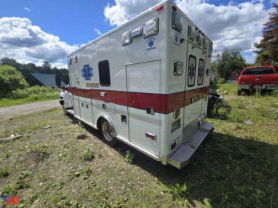 Ambulance back and side view showing medical graphics and red stripe along white body.