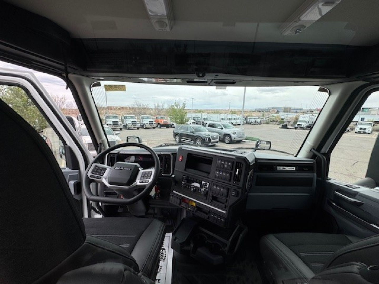 Cab interior of a 2027 Mack AN64T truck showing steering wheel and dashboard features.