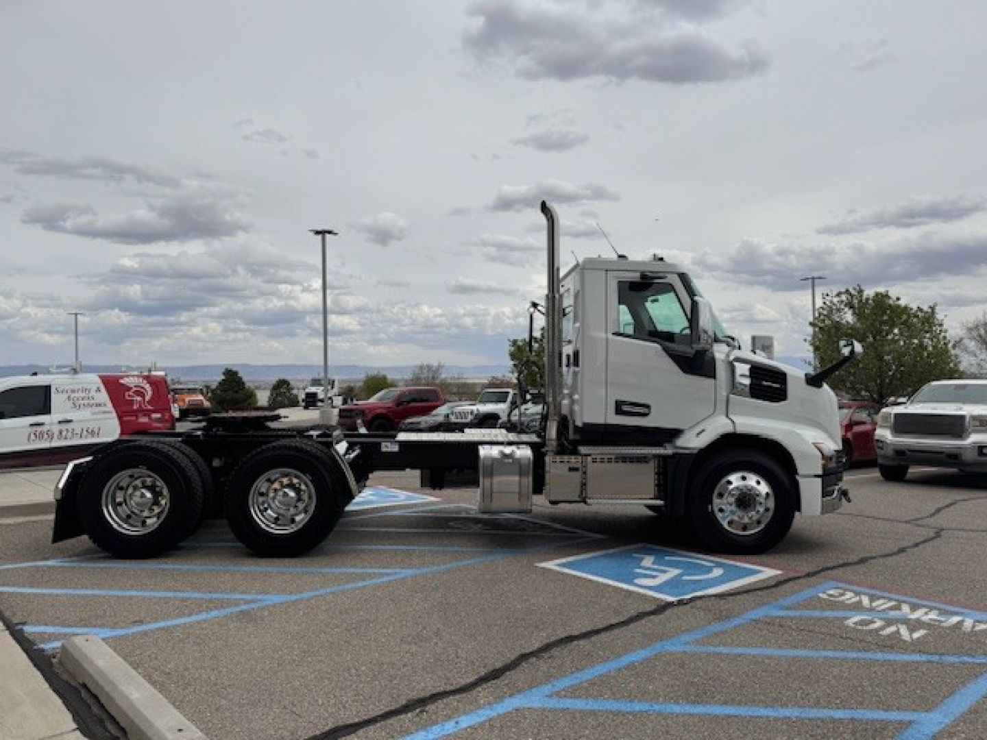 Side view of a white Mack AN64T daycab truck on a parking lot, showing the cab and chassis with dual rear axles.