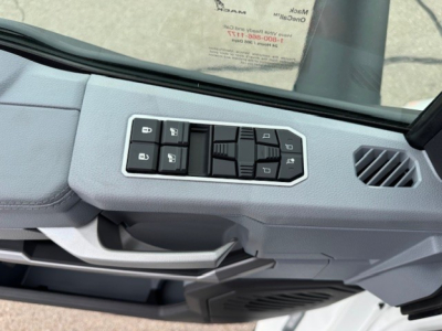 Cab interior panel with window control switches and door handle area visible.