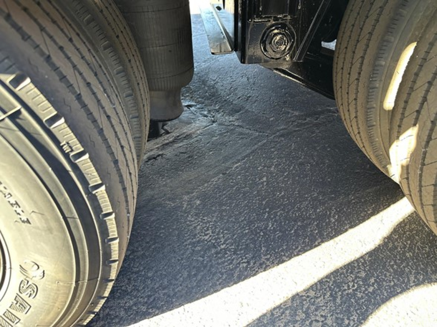 Flat view under a Doepker trailer showing dual rear axles and tires with air ride suspension components.