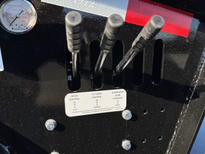 Doepker trailer control levers and a gauge panel with labels visible on black metal frame.