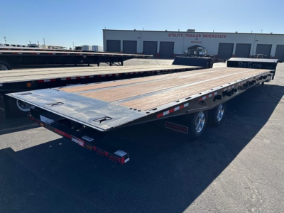 Doepker 40 ton slide axle trailer with 20k winch and air ride. Flatbed trailer with wooden deck and dual tandem axles, visible branding and racks.