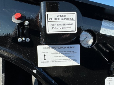 Winch clutch control label and instrument panel on Doepker trailer hitch, with push to engage/disengage instruction, hinge release label, and control lever.