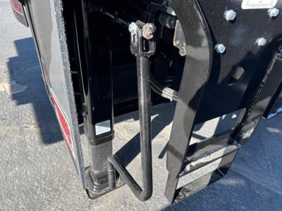 Doepker trailer component view showing hydraulic lift or support linkage and frame near wheel well, with bolts and metal brackets visible.