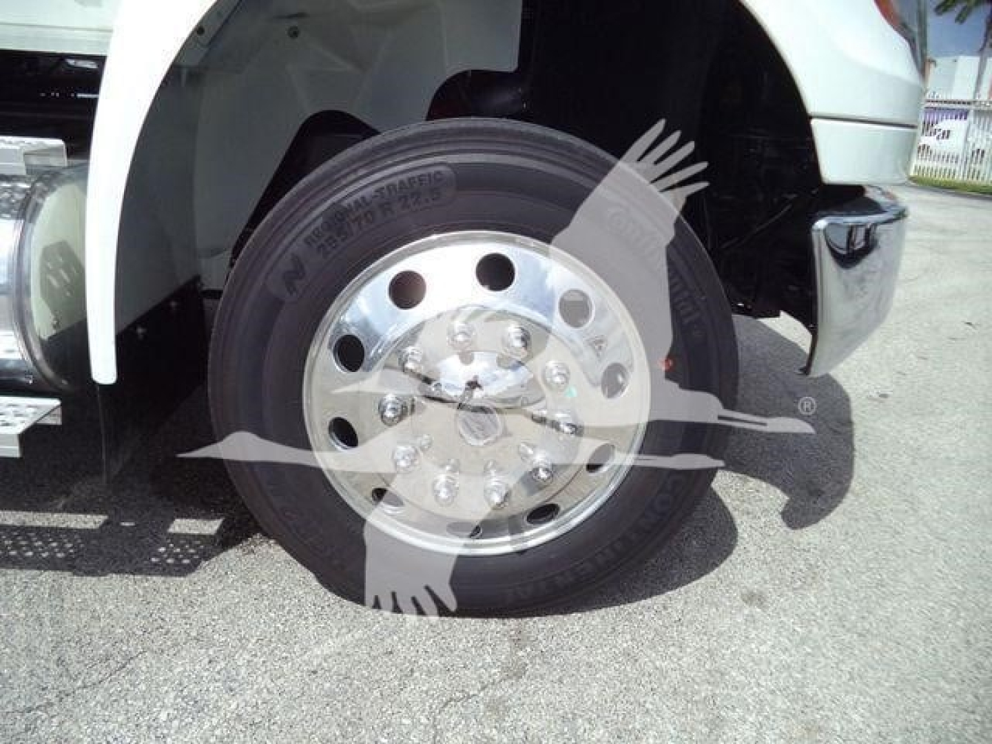 Truck front wheel showing chrome alloy rim and tire in close-up view