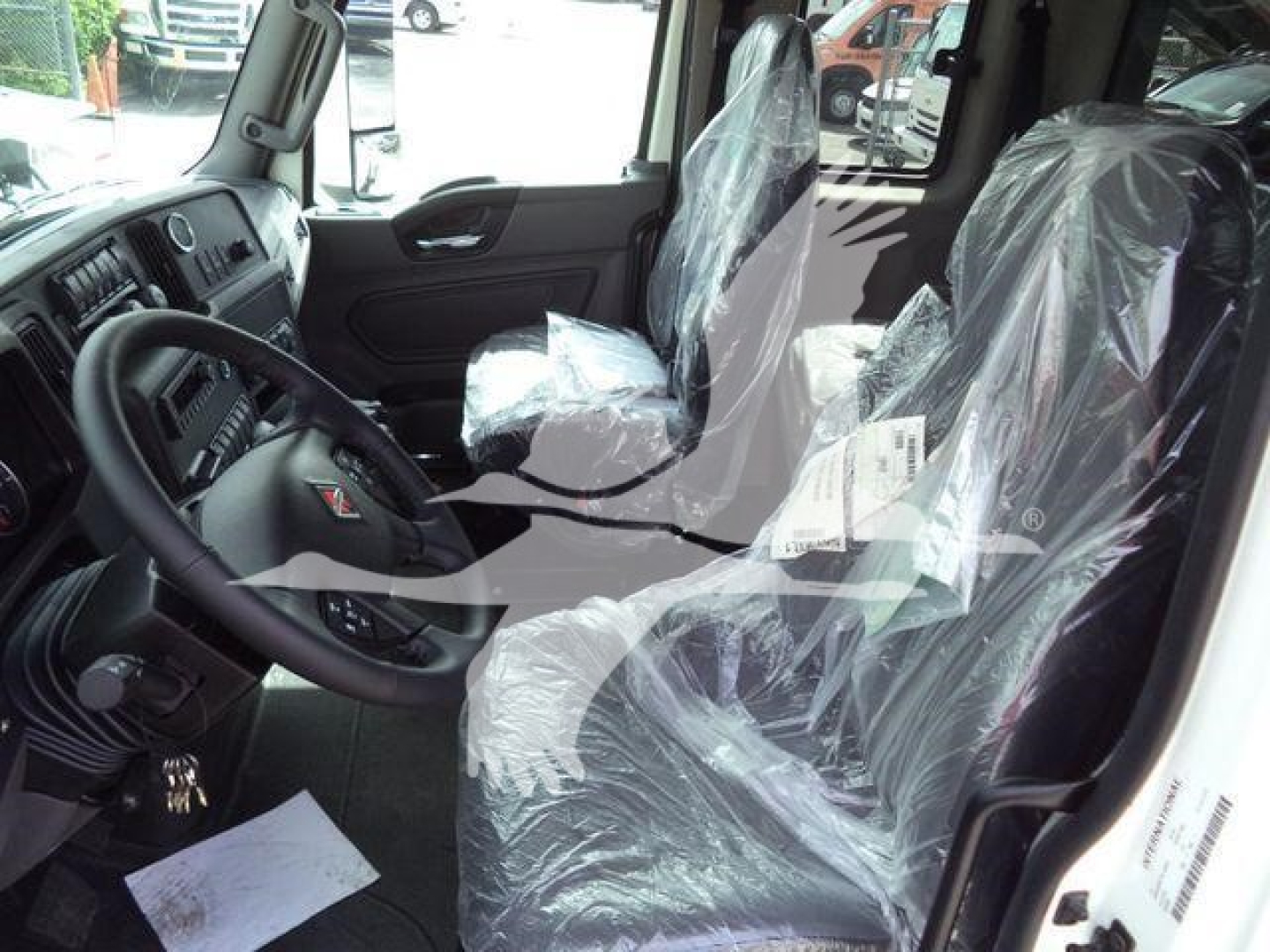 Truck interior showing cab with plastic-covered seats and dashboard view in MV model.