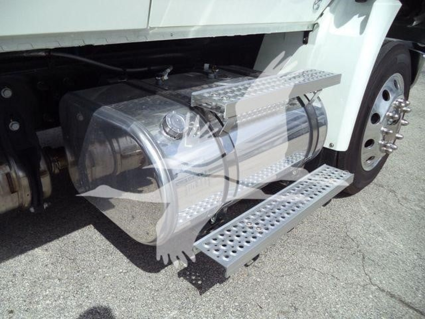 Truck side fuel tank with aluminum steps and chrome fuel tank visible. Portion of front wheel and chassis in view.