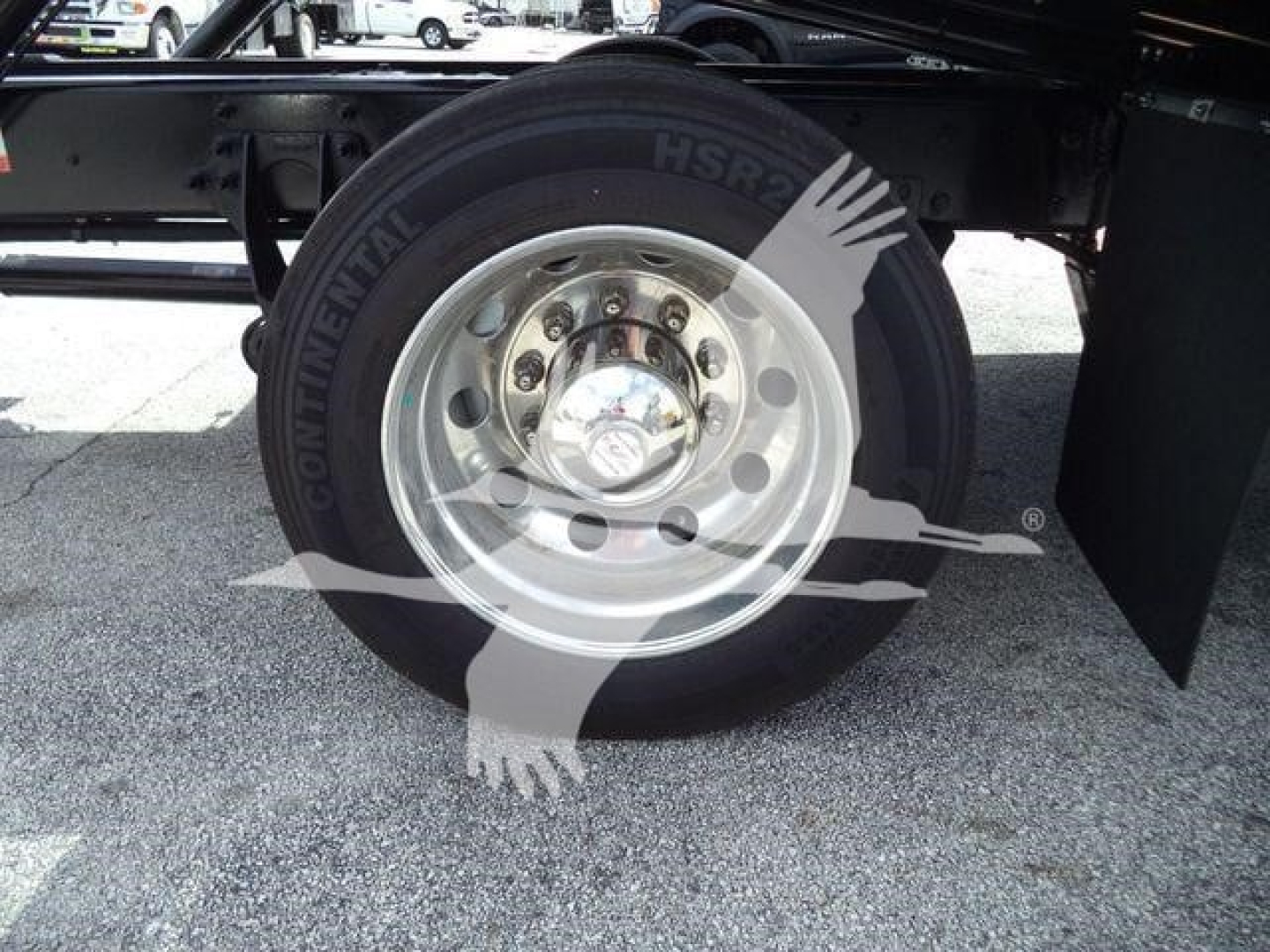 Wheel assembly and tire on a new International MV rollback truck showing a polished steel wheel with lug nuts and tire sidewall.