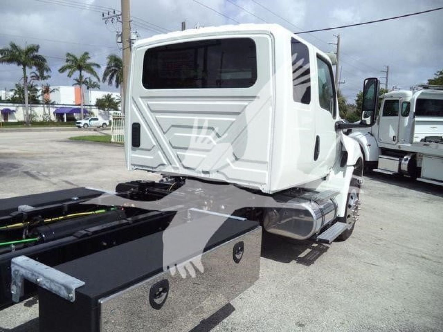 Truck cab rear view showing MV series International rollback truck with storage toolbox and chassis hitch.