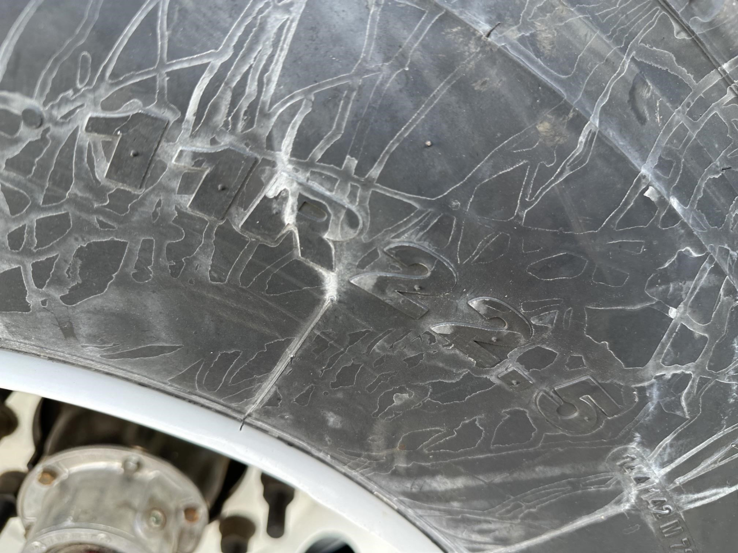 Hopper trailer wheel well area with visible surface scratches and scuff marks on tire sidewall.