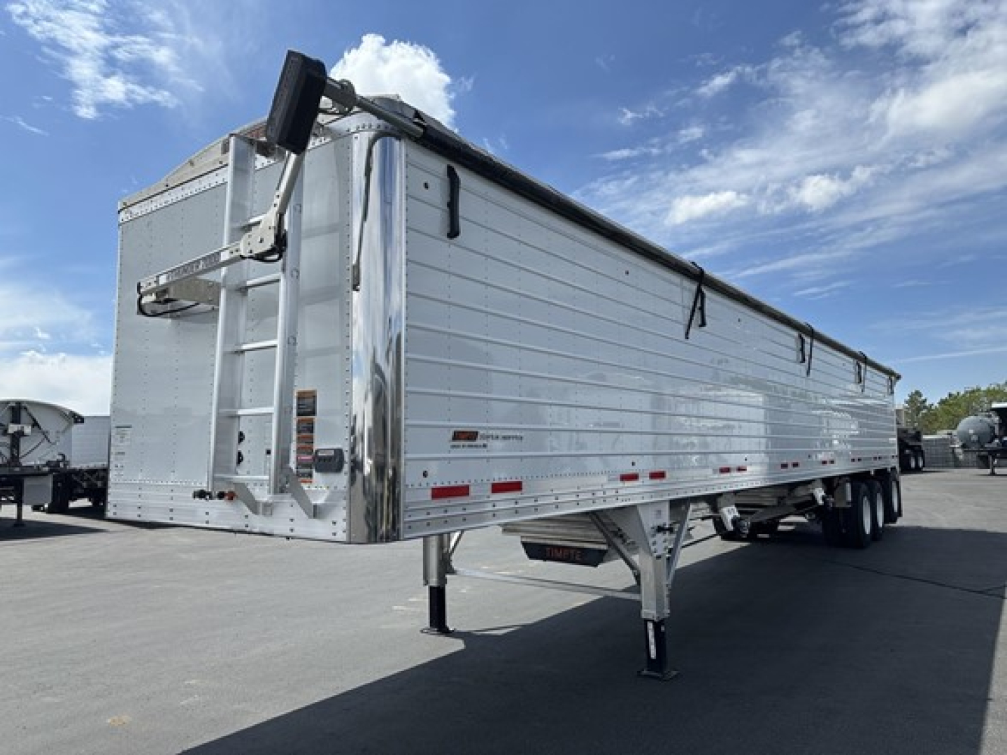 Timpte Super Hopper Tri Axle trailer side view showing dual-axle configuration and raised landing gear.
