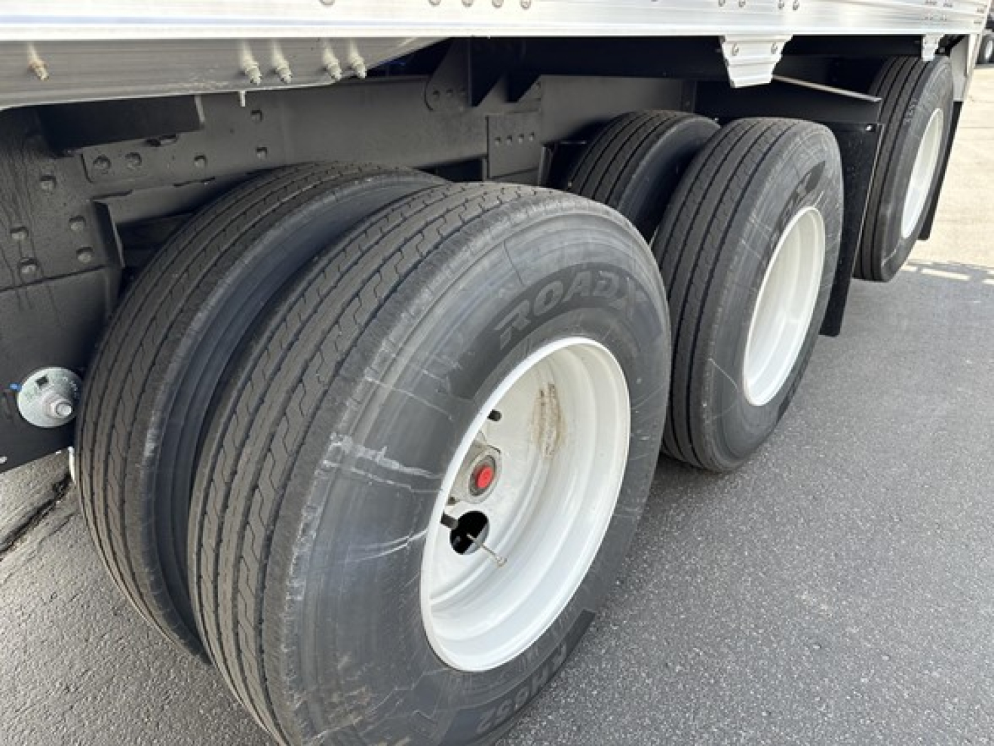 Timpte Super Hopper Tri Axle trailer wheel set with dual rear axles and Goodyear tires visible.