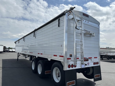 Timpte Super Hopper Tri Axle trailer rear and side view showing aluminum cargo box, wheels, ladder, and rear doors.