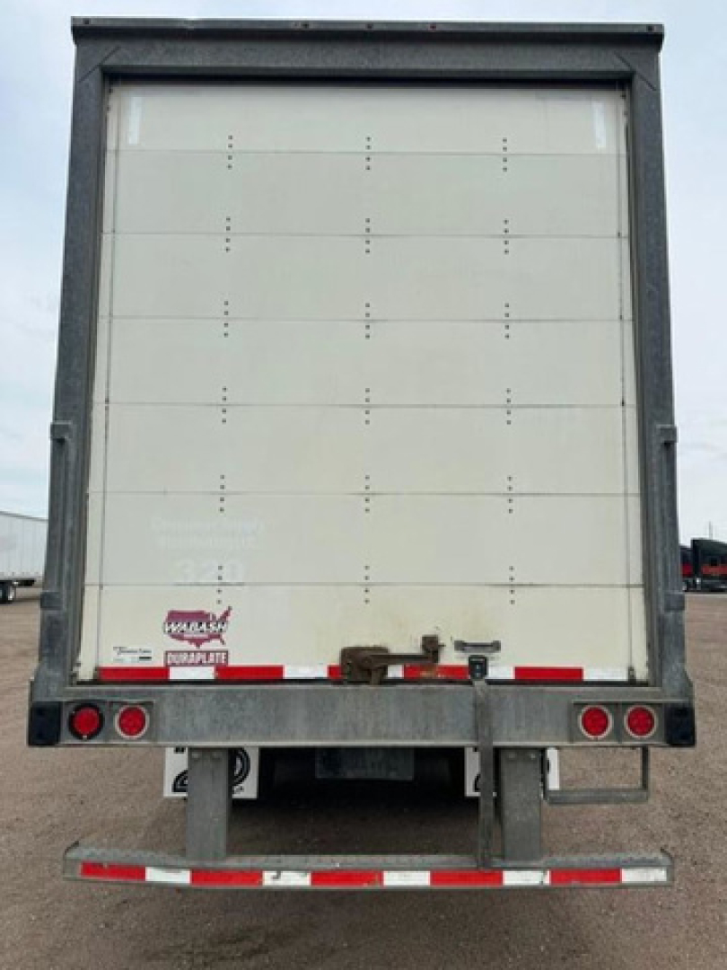 Trailer rear view showing closed vertical-raise van doors, metal frame, taillights, and rear underride guard.