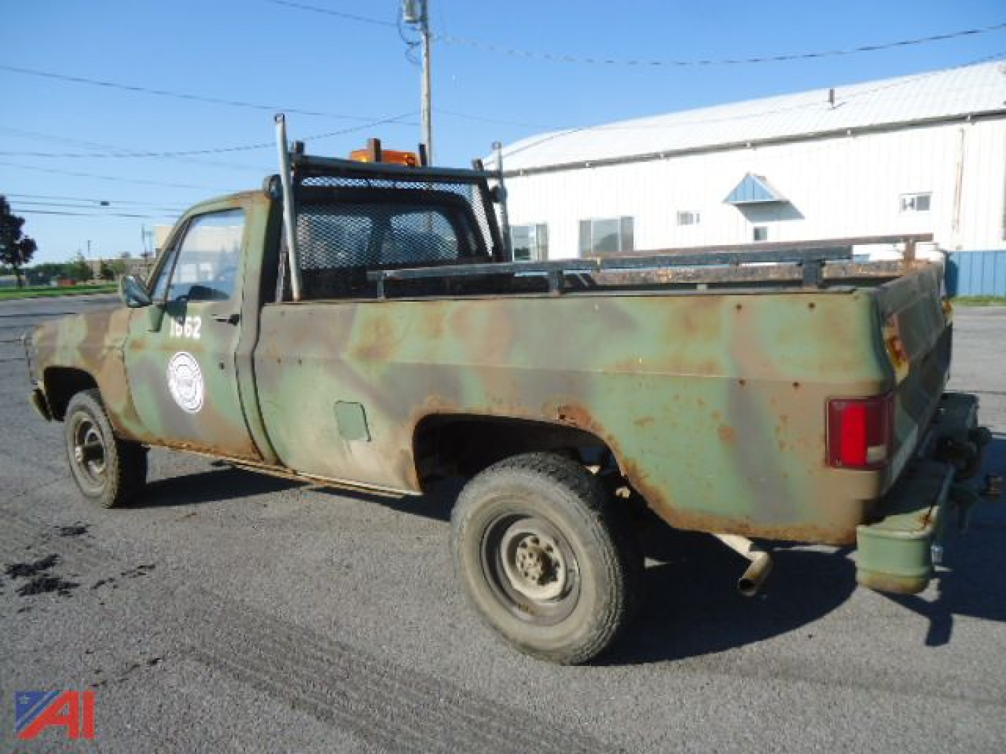 Military-style 1985 Chevrolet D30 pickup truck with rusted green body, 4x4, long bed, rear hitch, and winch area.