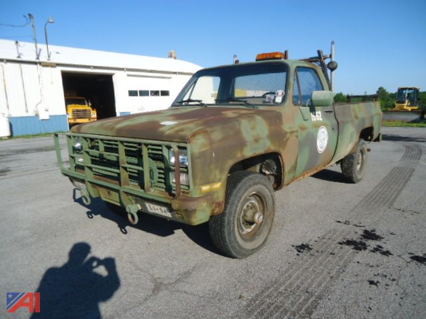 Chevrolet military D30 pickup truck showing weathered green paint with rust spots and front bumper guard in a yard.