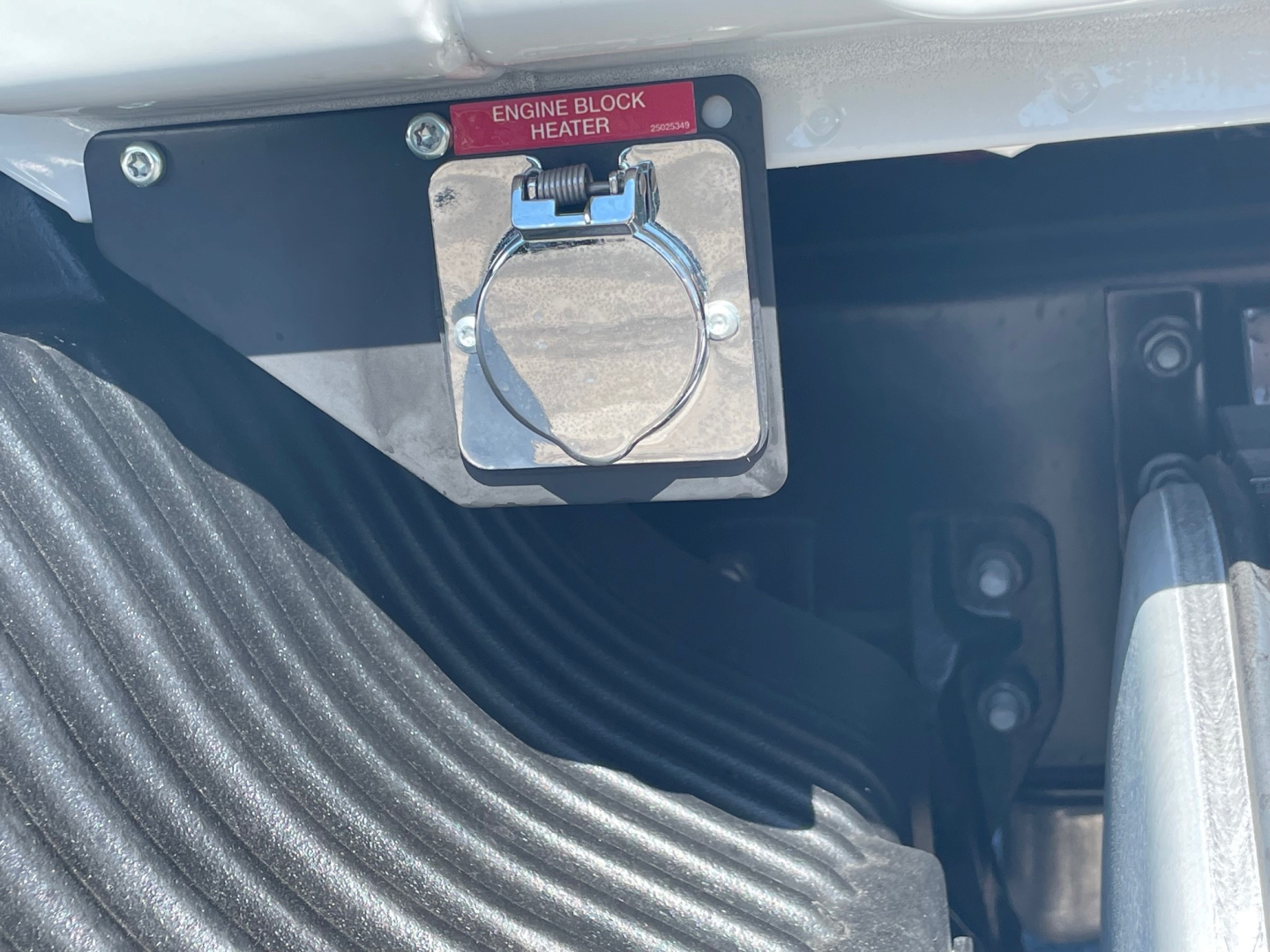 Engine block heater plug on Mack MD6 engine bay area with label Engine Block Heater visible