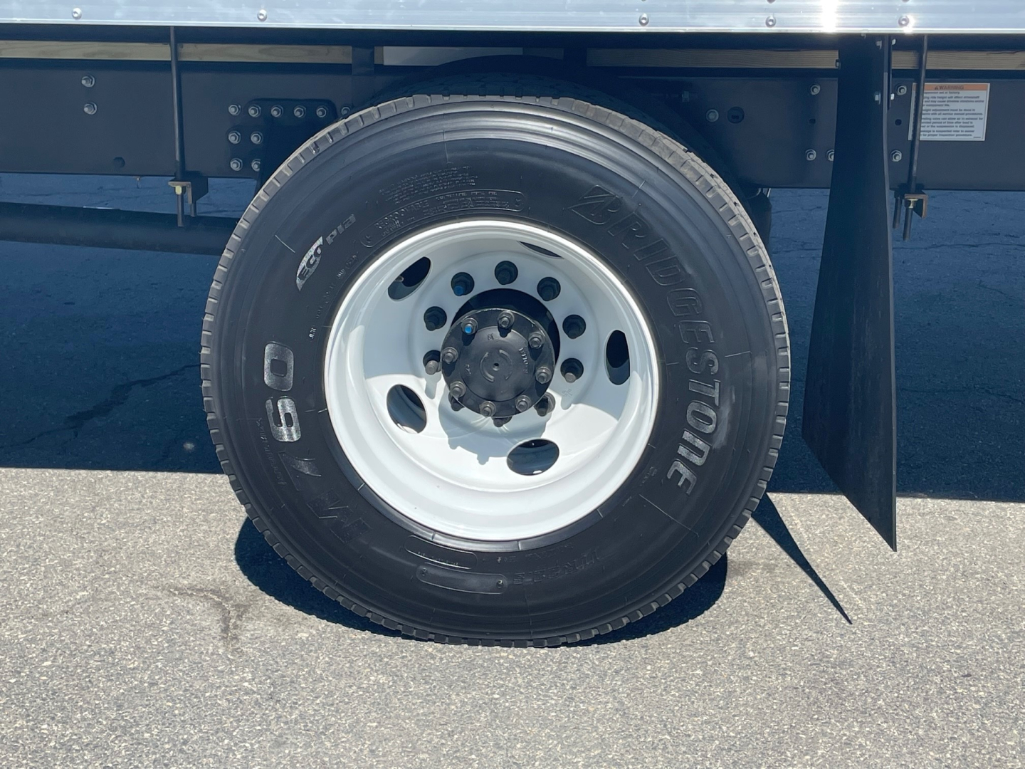 RHS front wheel of a 2025 Mack MD6 truck showing a 19.5-inch steel wheel with a 225/70R19.5 tire, white rim, surrounding chassis and part of the underbody.