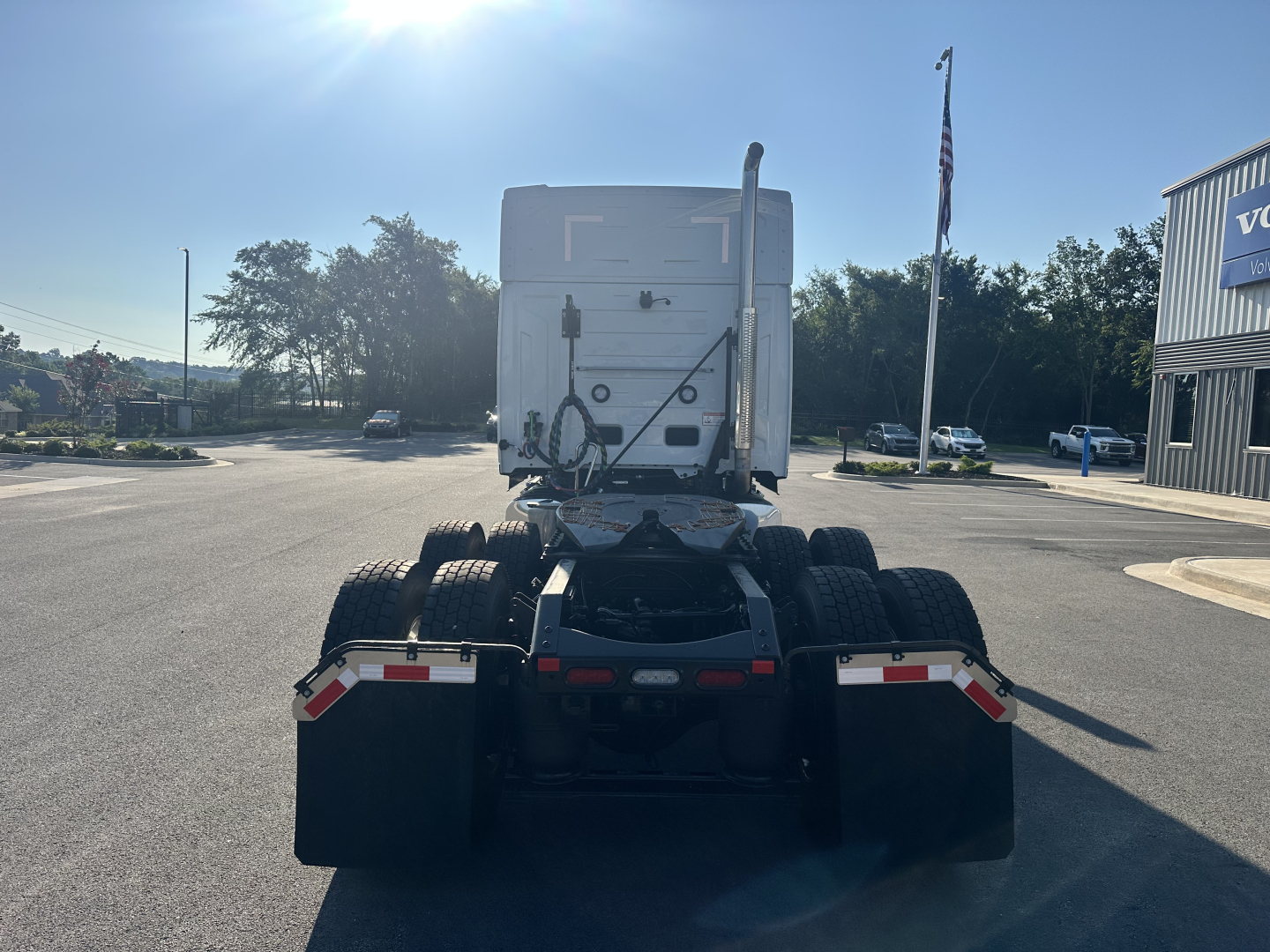 Truck chassis and fifth wheel area of a new Mack PR64T76M tractor showing rear view with dual rear axles and fifth-wheel coupling.