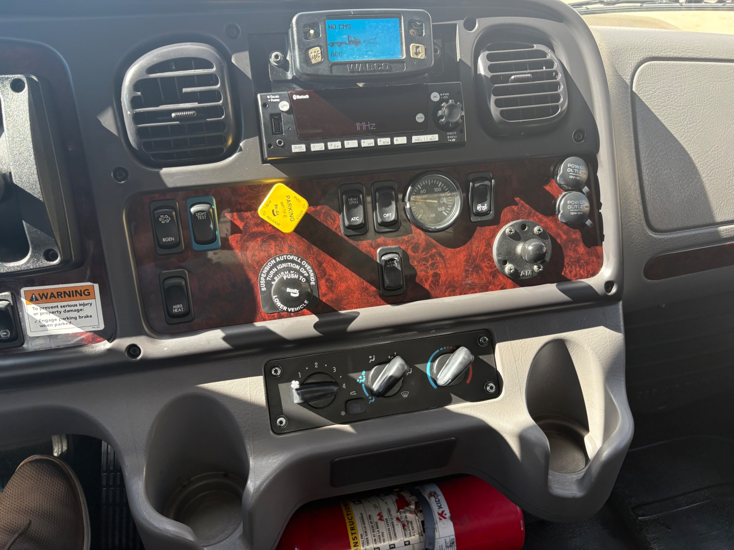 Dashboard of a Freightliner M2-106 showing control panel, gauges, and HVAC vents.