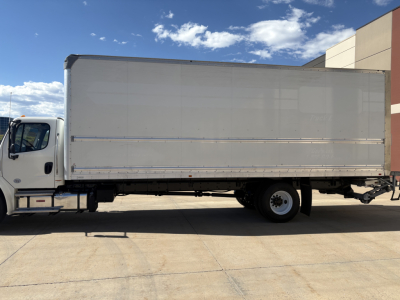 Box truck side view showing cargo box on Freightliner M2-106 with white exterior and blank cargo area.