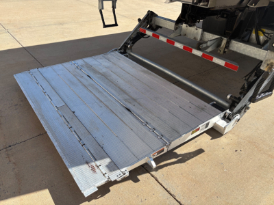 Freightliner M2-106 rear with aluminum empty liftgate/platform in lowered position, showing loading ramp and truck chassis.