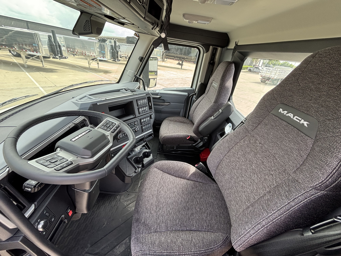 Mack AN64T truck cab interior showing steering wheel, dashboard, and driver seat with Mack branding.
