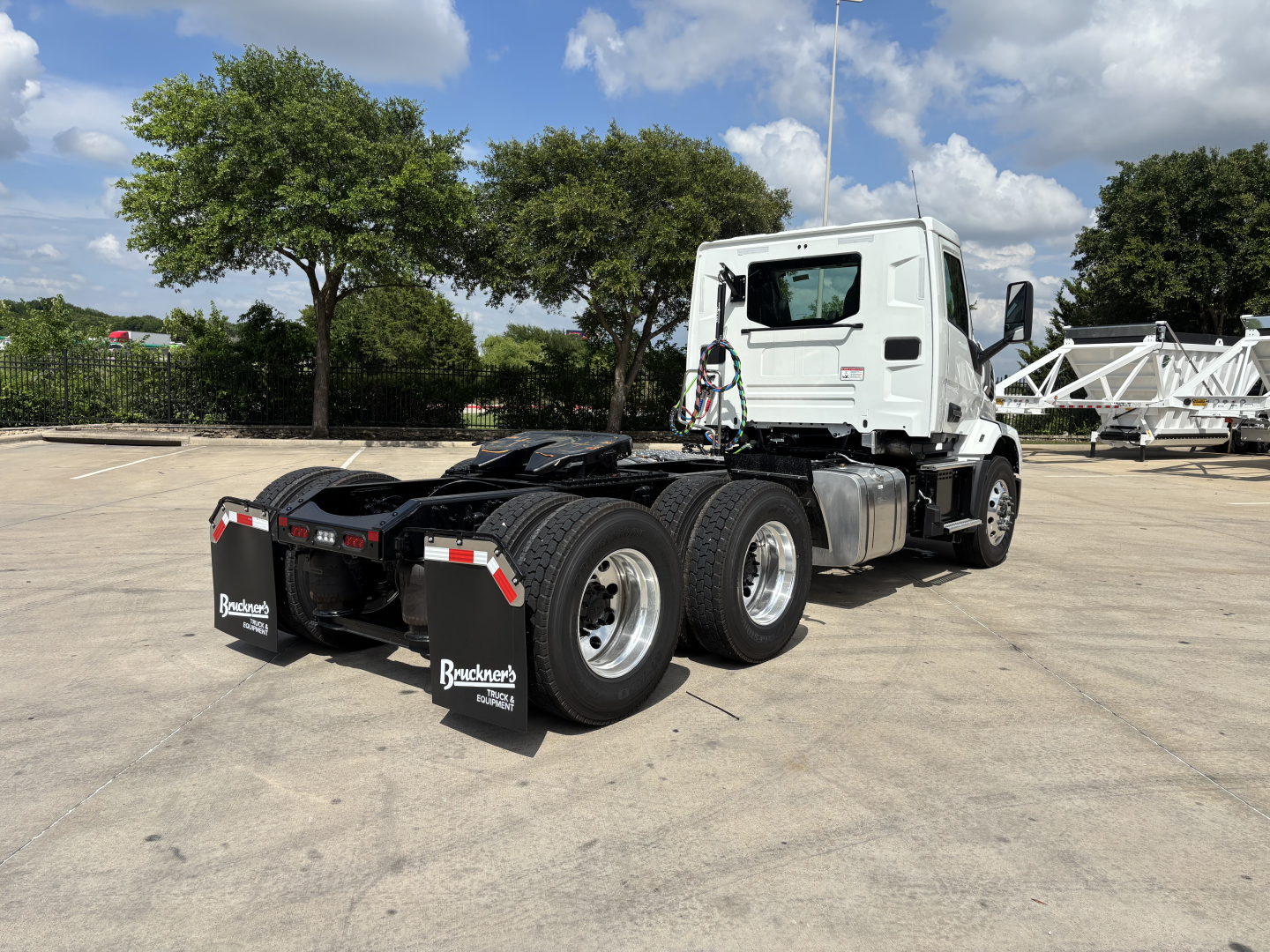 Mack AN64T conventional daycab truck viewed from rear 3/4 angle showing dual rear axles and mud flaps