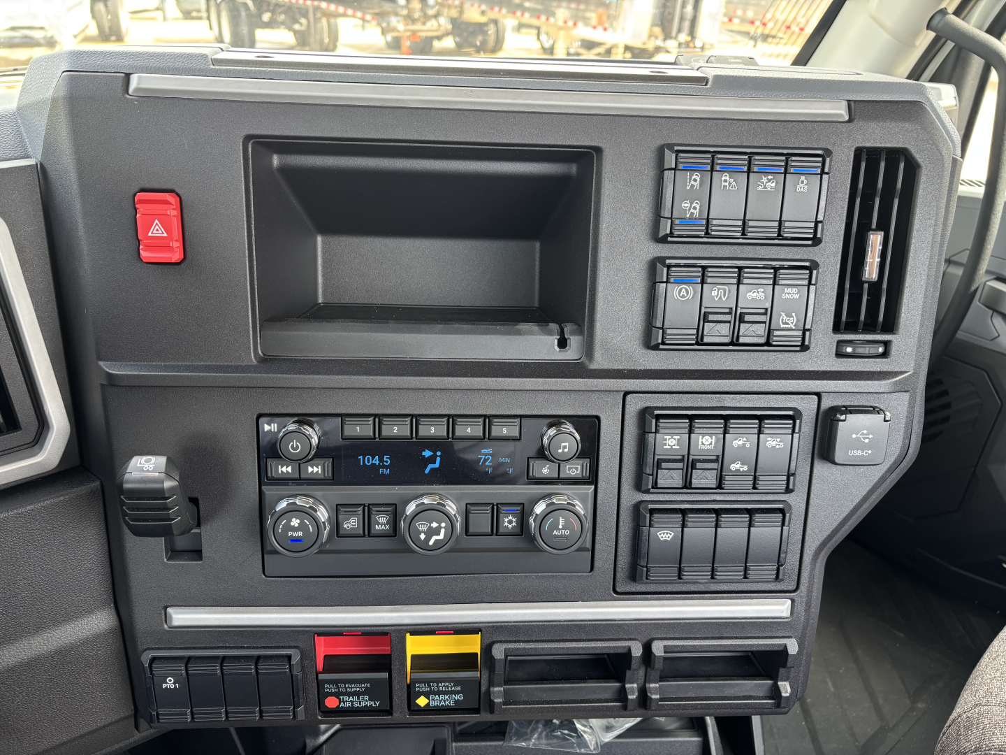 Interior dashboard of a 2027 Mack AN64T showing instrument cluster, climate controls, and switch panels.