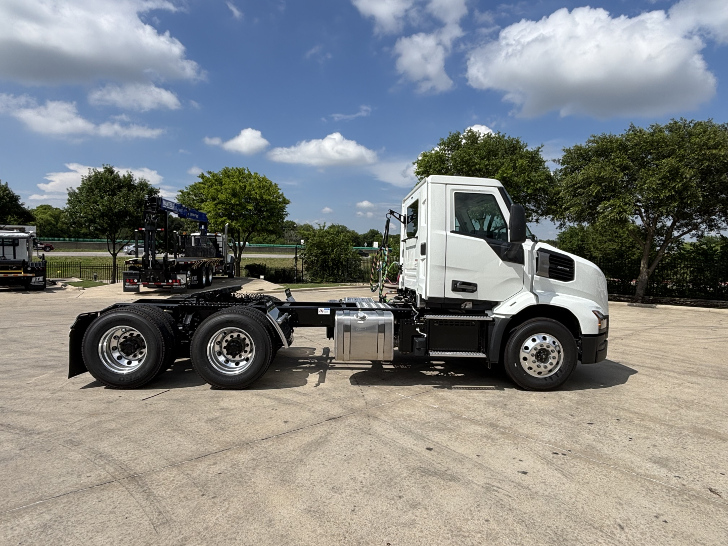 Truck side view showing Mack AN64T cab and chassis with fuel tank and dual rear axles.