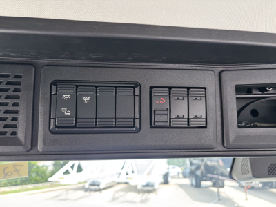 Dashboard switches panel with multiple rocker switches and labeled buttons visible in cab interior.
