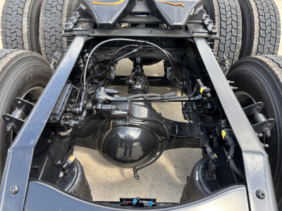 Rear view of a Mack AN64T chassis showing differential housing, axles, and suspension components under a Daycab truck.