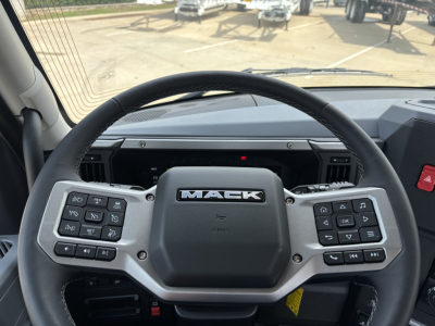 Mack AN64T truck steering wheel with control buttons visible in cab view.