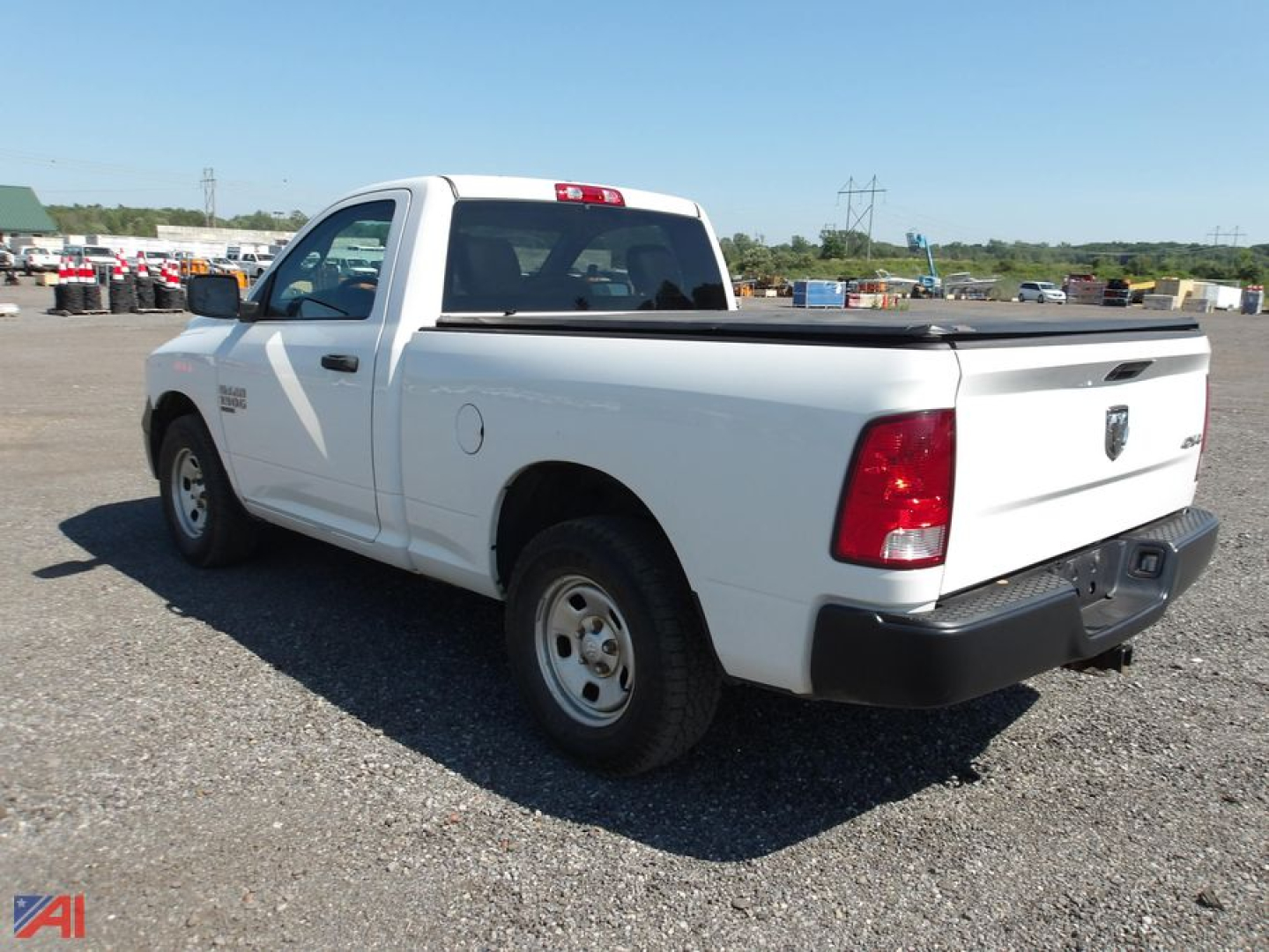 White Ram 1500 Classic pickup truck in a gravel lot, rear three-quarter view, short bed, 2-door regular cab, 4x4 badge on side.
