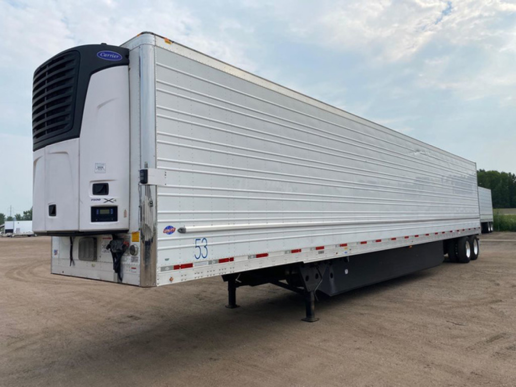 Refrigerated trailer showing Carrier APU unit at front left, silver ribbed sides, and support legs extended. VIN 1UYVS2534M2382625 visible with stock U91111.