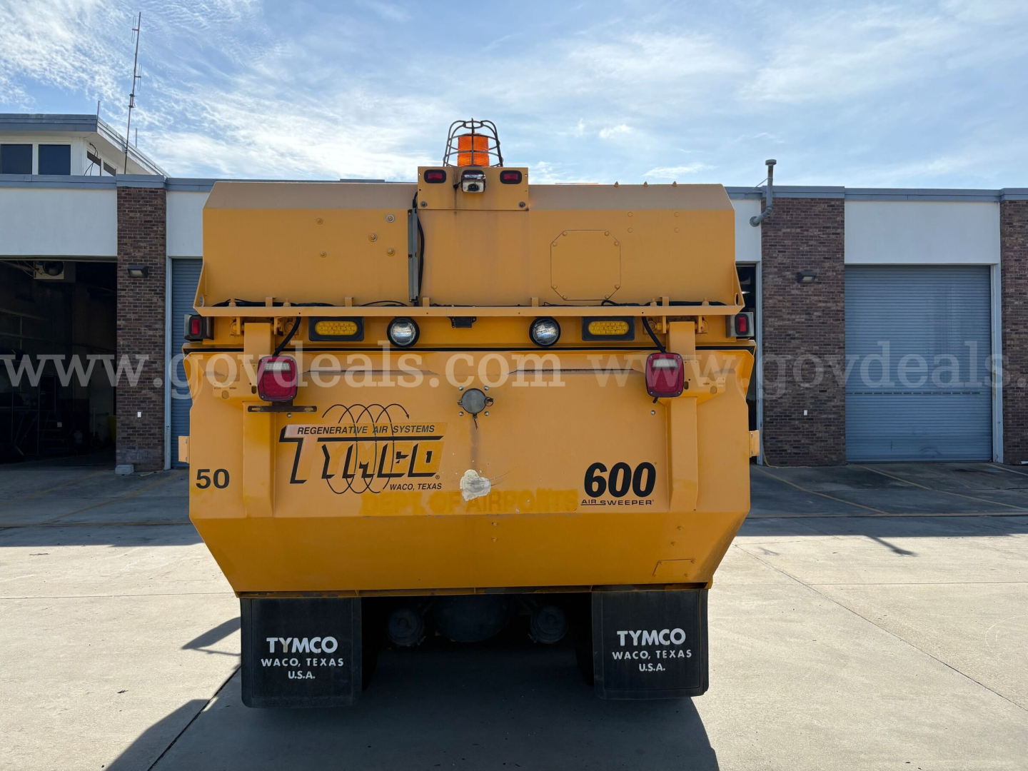 Rear view of a yellow 2012 International DuraStar sweeper truck showing TYMCO mud flaps and water fill area with stock number 204-3538. 600 and 50 decals visible.