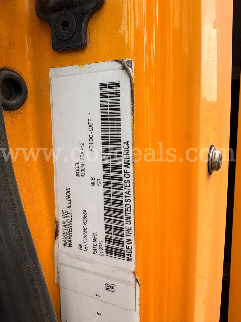 Truck VIN sticker on yellow International DuraStar door frame showing Made in USA of America, model 4301, date 13-? and weight details.