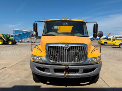 Front view of a yellow 2012 International DuraStar truck showing large grille, bumper, and side mirrors.
