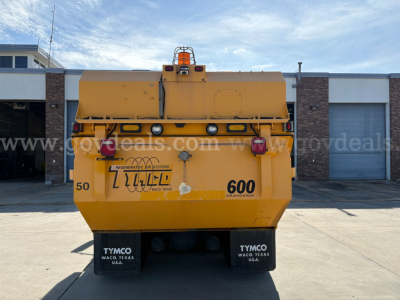 Rear view of a yellow 2012 International DuraStar sweeper truck showing TYMCO mud flaps and water fill area with stock number 204-3538. 600 and 50 decals visible.