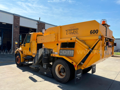 International DuraStar sweeper truck showing bright yellow hopper and 600 label with VIN 1HTJTSKN8CJ536664 on the body.