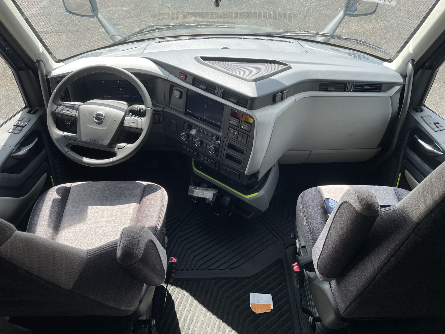 Volvo VNL64T660 cockpit with steering wheel, dashboard, and two front seats visible.