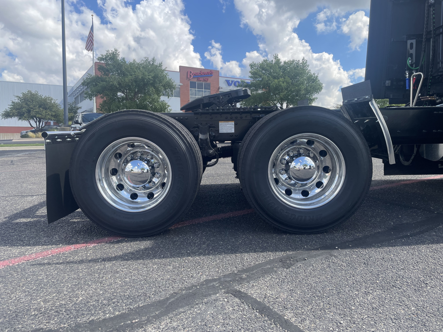 Volvo VNL64T660 truck rear wheels and chassis showing dual rear axles and chrome wheels with black tires.