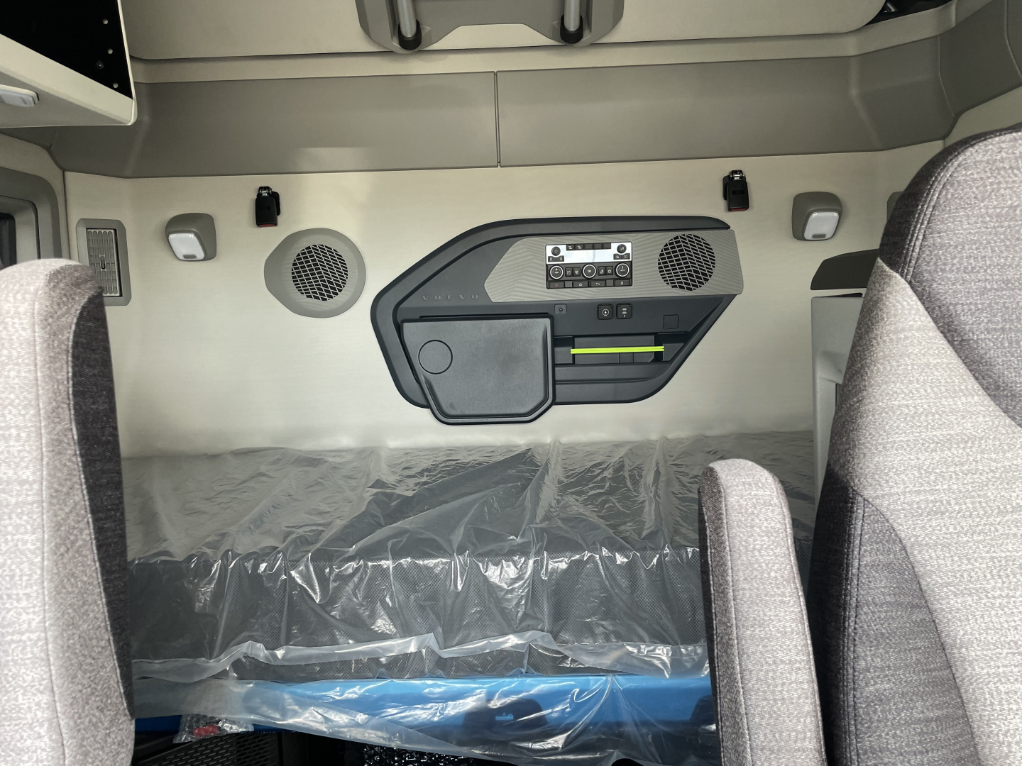 Volvo VNL64T660 sleeper cab interior showing control panel and storage compartment on dash with speaker grilles.