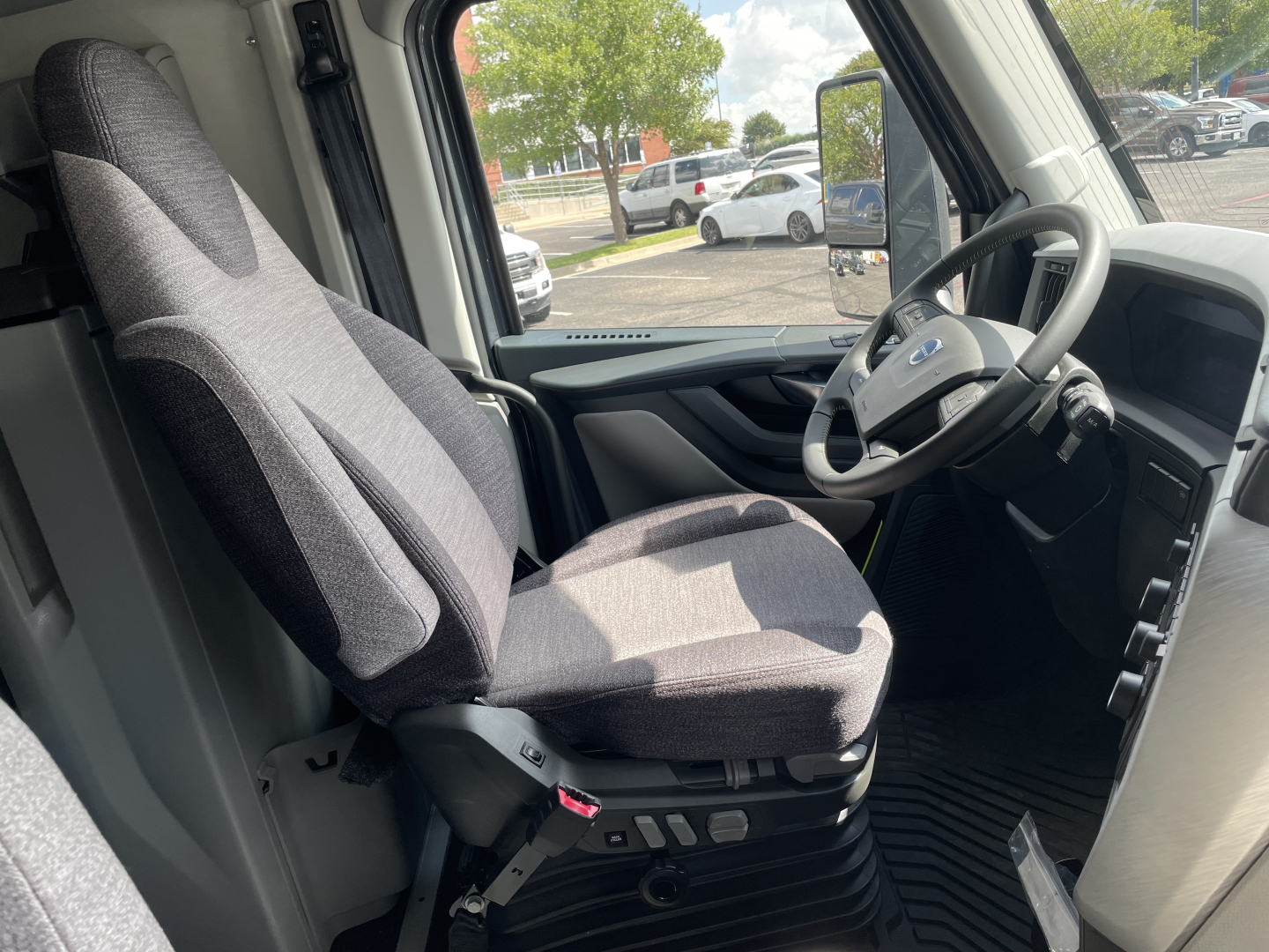 Volvo VNL64T660 truck interior showing driver seat and steering wheel with dashboard and pedals.