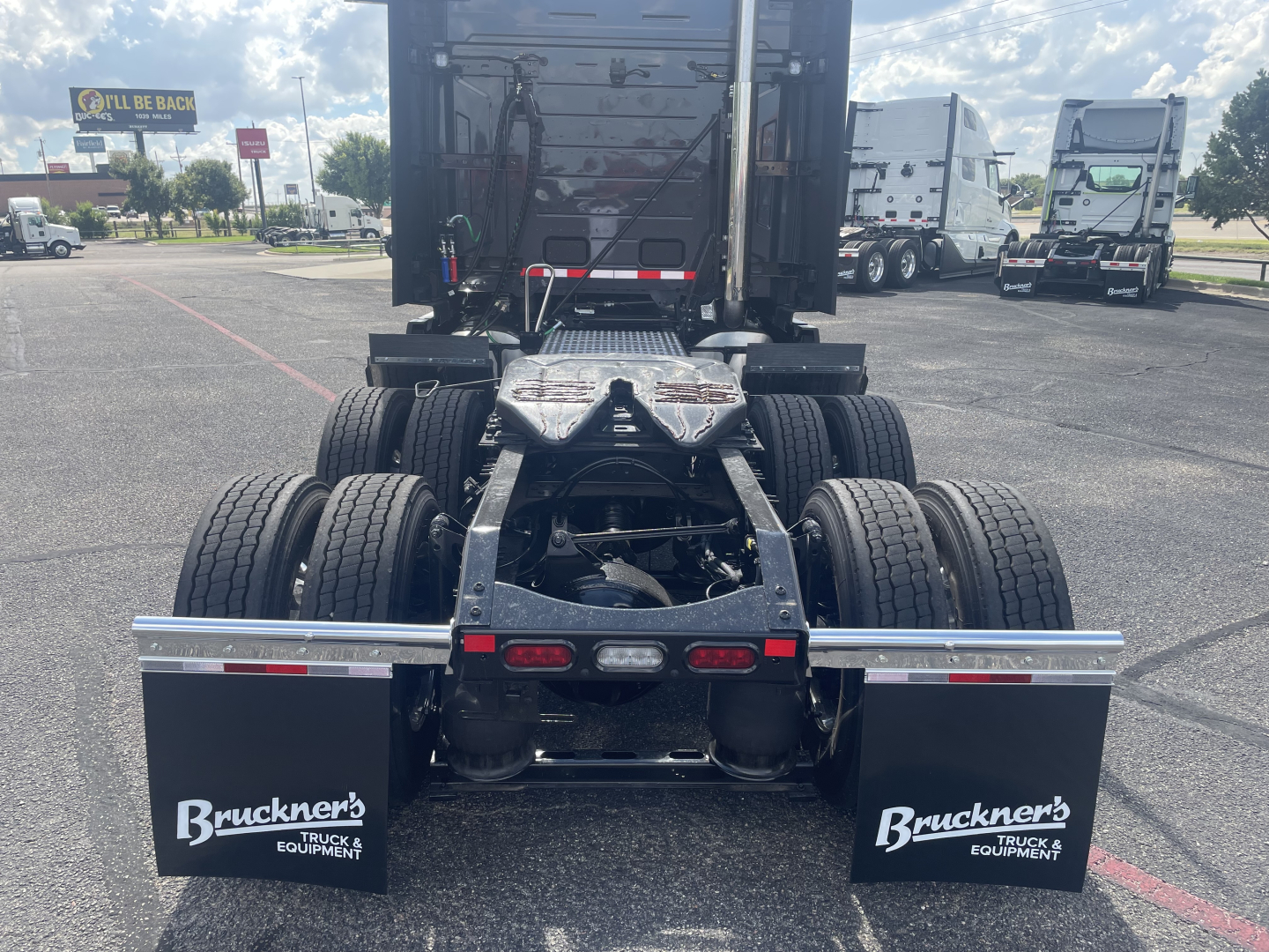 Rear view of a Volvo VNL64T660 tractor chassis showing dual rear axles, fifth wheel, and mud flaps labeled 'Bruckners Truck Equipment' with reflectors and license-plate area.