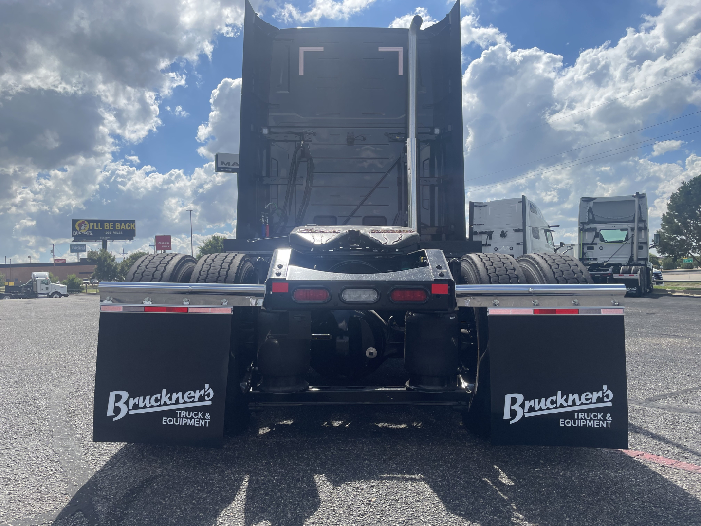 Volvo VNL64T660 truck rear view showing dual mud flaps with Brucker’s Truck & Equipment logo, trailer kingpin area, and fifth-wheel beneath a raised sleeper cab.