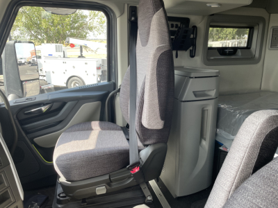 Volvo VNL64T660 cab interior showing driver seat, dashboard, and sleeper area with fridge and bunk bed.