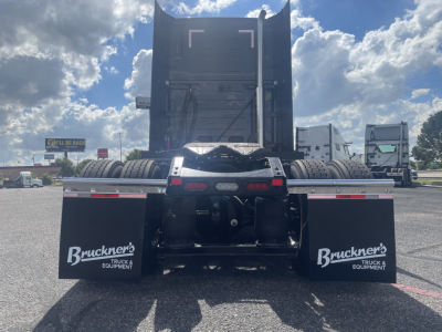 Volvo VNL64T660 truck rear view showing dual mud flaps with Brucker’s Truck & Equipment logo, trailer kingpin area, and fifth-wheel beneath a raised sleeper cab.